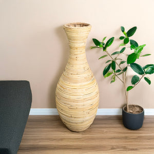 Detaillierte, beige Bodenvase, unten breit und oben dĂĽnn in einem zweiten Anwendungsbeispiel mit beiger Wand im Hintergrund