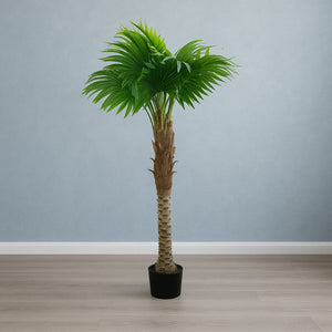 Künstliche Palme mit schwarzem Topf in einem Aufstellbeispiel mit blauer Wand