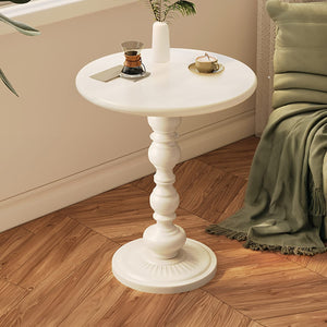 Runder, weisser Couchtisch mit detaillierter Stütze in einem Anwendungsbeispiel mit Kaffee neben einem Sessel