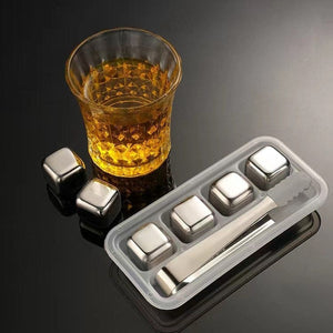 Edelstahl-KĂĽhlsteine mit Glas und Zange vor der Form der Steine und der Zange