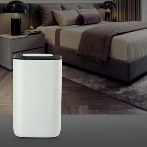 weiss-schwarzer Luftentfeuchter mit Schlafzimmer im Hintergrund
