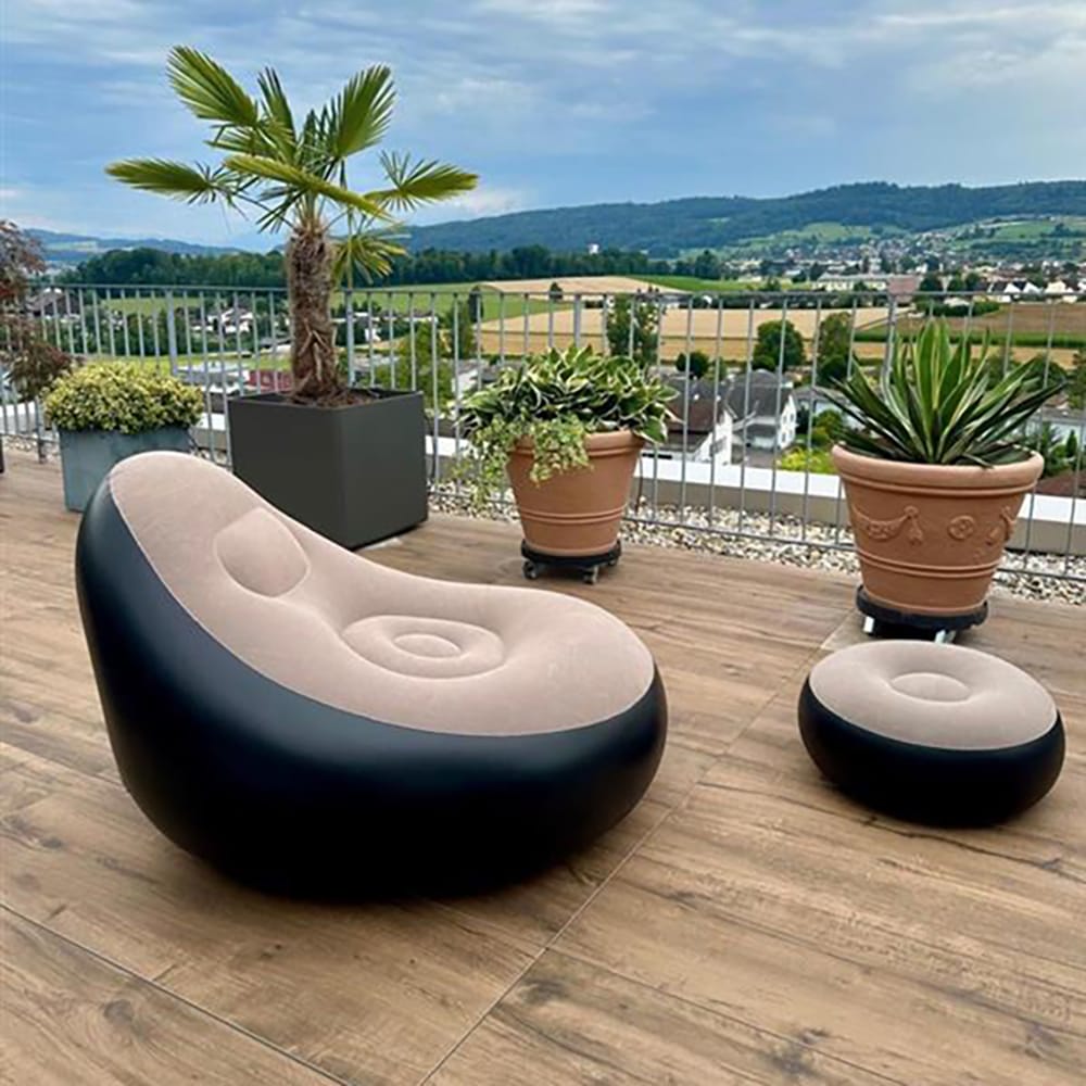 Aufgeblasener, beige-schwarzer Sessel mit kleinem aufgeblasenem Fusshocker in einem Aufstellbeispiel auf einem Balkon