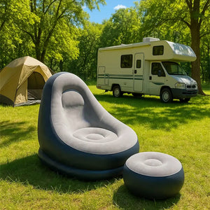 Aufgeblasener, grau-schwarzer Sessel mit kleinem aufgeblasenem Fusshocker in einem Aufstellbeispiel auf einem Campingplatz