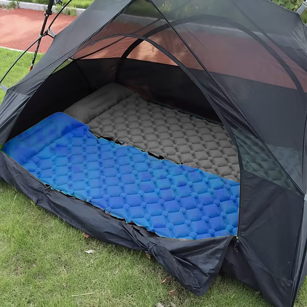 Blaue und graue Camping-Matratze in einem Zelt nebeneinander gelegt