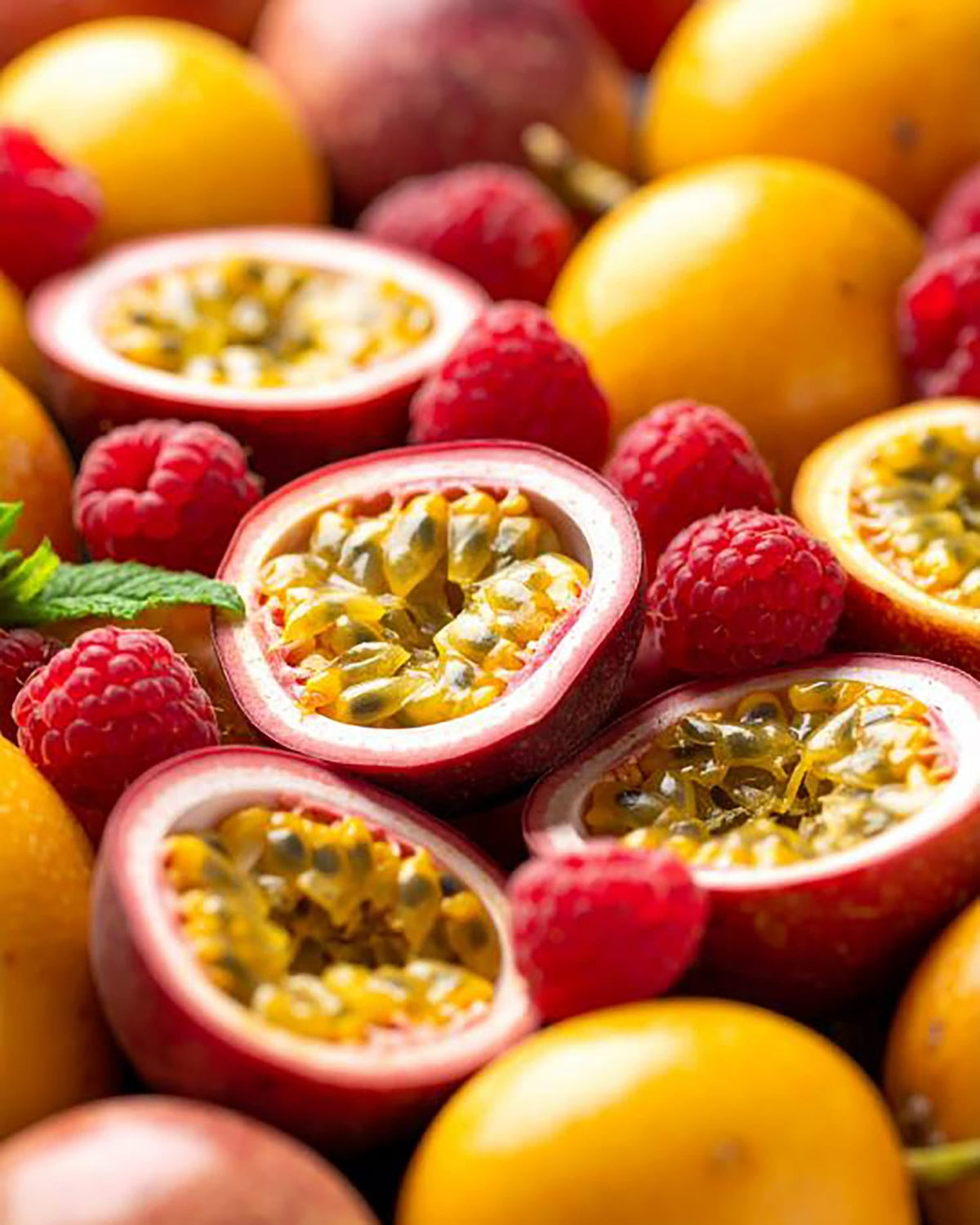 Aufgeschnittene Passionsfrüchte und Himbeeren
