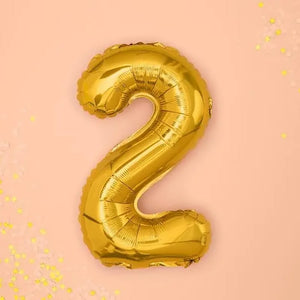 Goldener "2" Ballon auf rosa Hintergrund