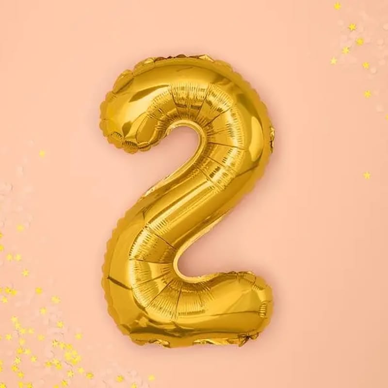 Goldener "2" Ballon auf rosa Hintergrund