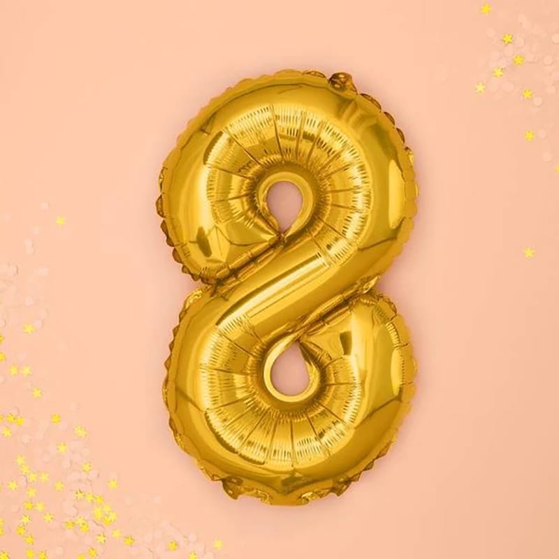 Goldener "8" Ballon auf rosa Hintergrund