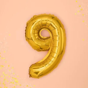Goldener "9" Ballon auf rosa Hintergrund